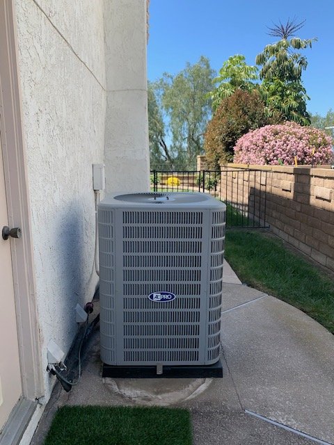 AC condenser installed in a residential side yard in the Left Coast Air service area